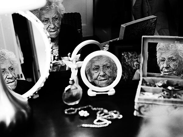 Photographie d'une personne âgée reflétée dans plusieurs miroirs